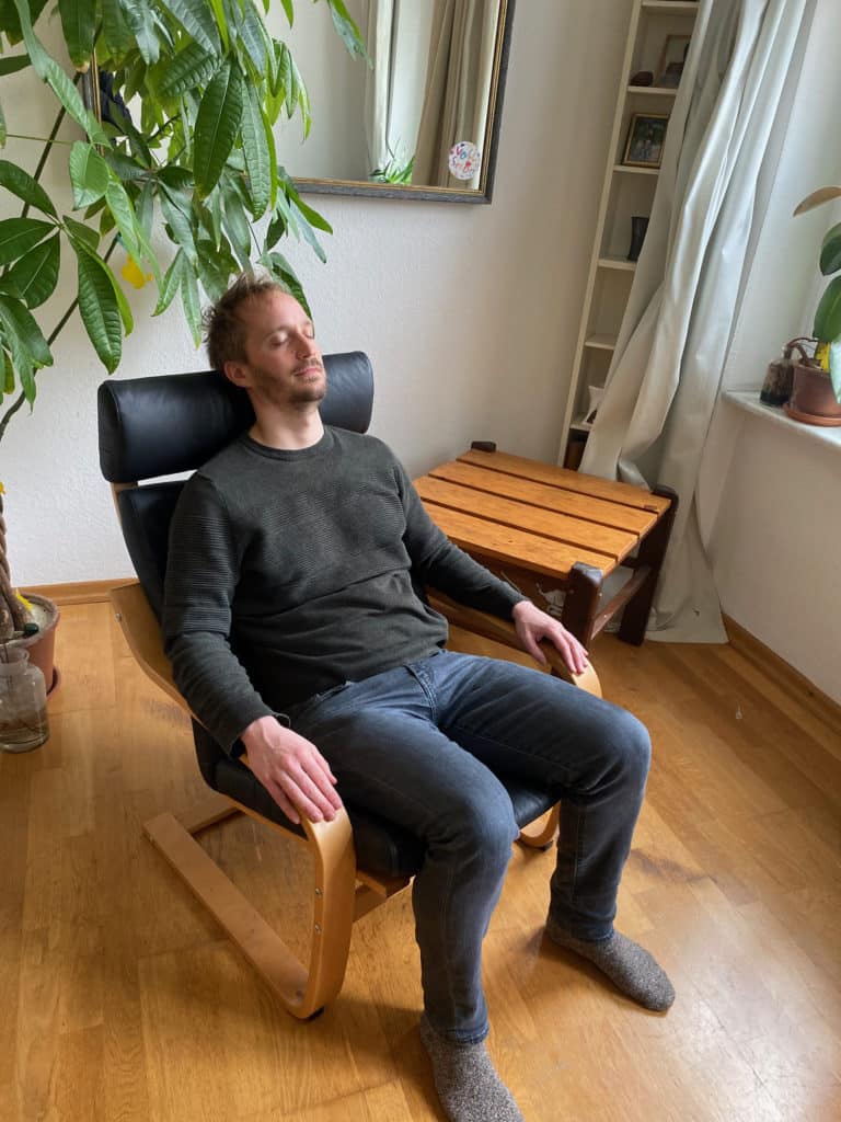 Ole Roloff sitzt aufrecht mit offenen Händen in einem Schwingsessel