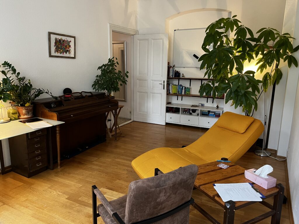 Ruhiger Raum mit Liege, Sessel und Pflanzen im Altbau